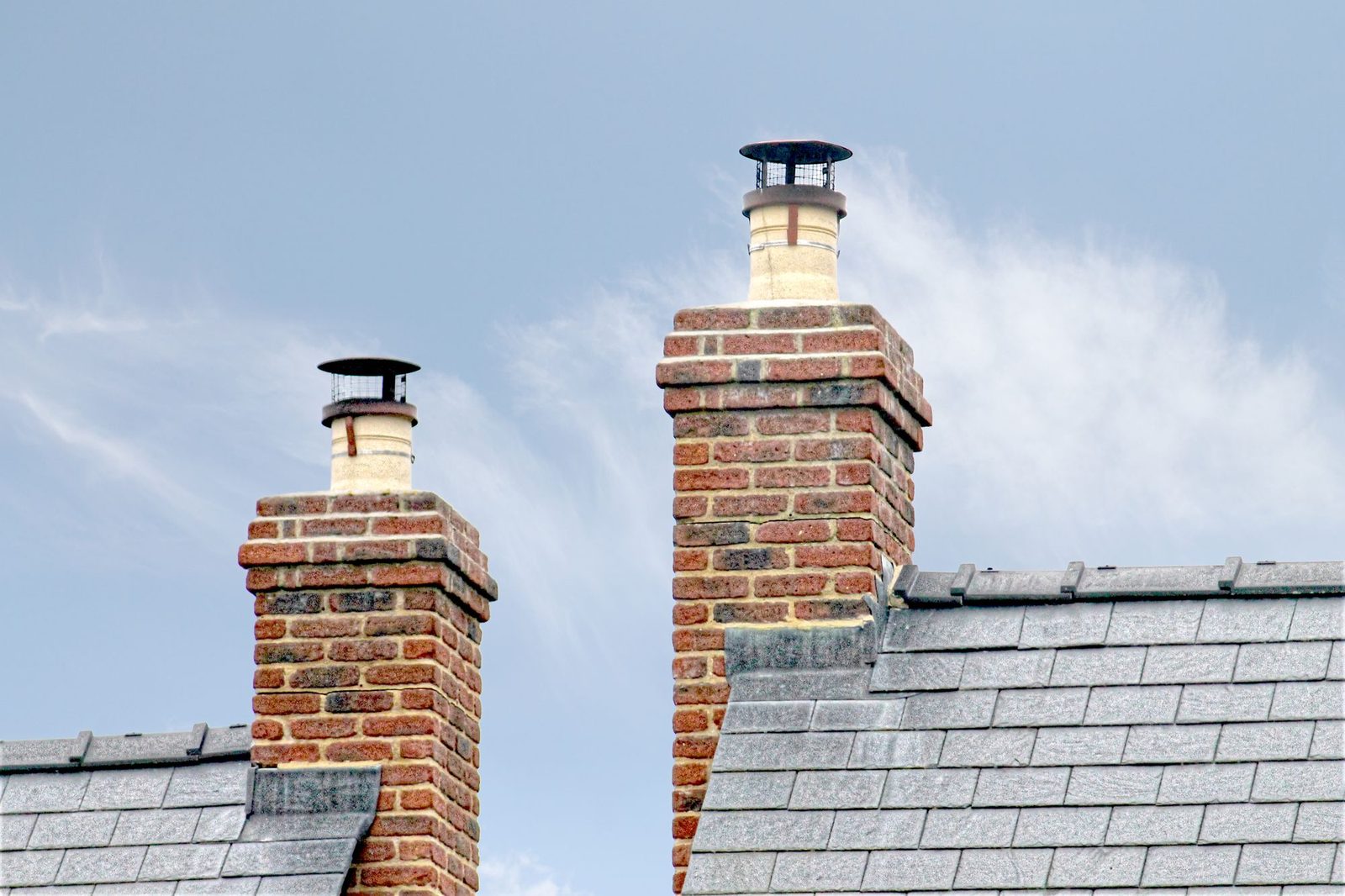 Brick chimneys with cowls on a slate roof